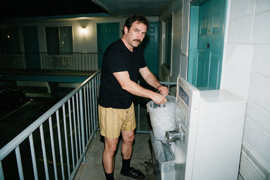 Man filling an ice bucket at a motel at night