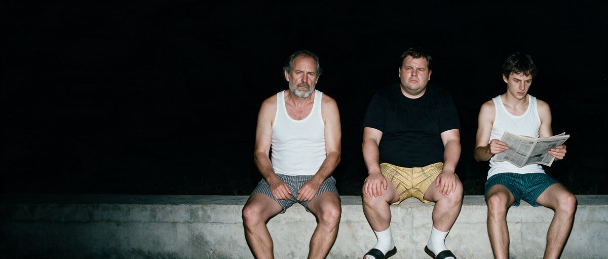 Three men in Mody basics lit by flash at night
